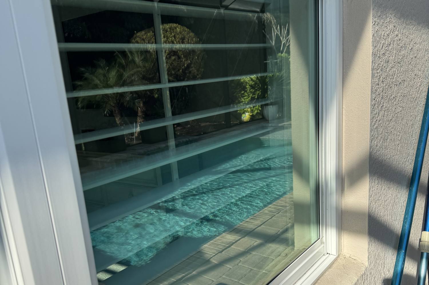 Clear view through a freshly cleaned window to a screened pool in Cape Coral, Florida